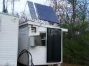 Outside view of the ham shack. There are two solar panel systems. One set  of panels is 540 watts while the smaller set is an old pair of 34 watt panels. Both make 12 volts and I combine them indoors to get 24 VDC for running relays etc.The big 12 volt panels charge up a 550 amp hour set of PV batteries. The big dark thing stuck on the outside wall of the shack is a solar hot air heater that makes warm air whenever the Sun is out. It helps heat the shack in winter. I also have a 9500 BTU vented propane heater inside. The big dog house stuck on the outside wall to the left of the heater is a remote blower for the 50 MHz KW amplifier that resides inside the shack.